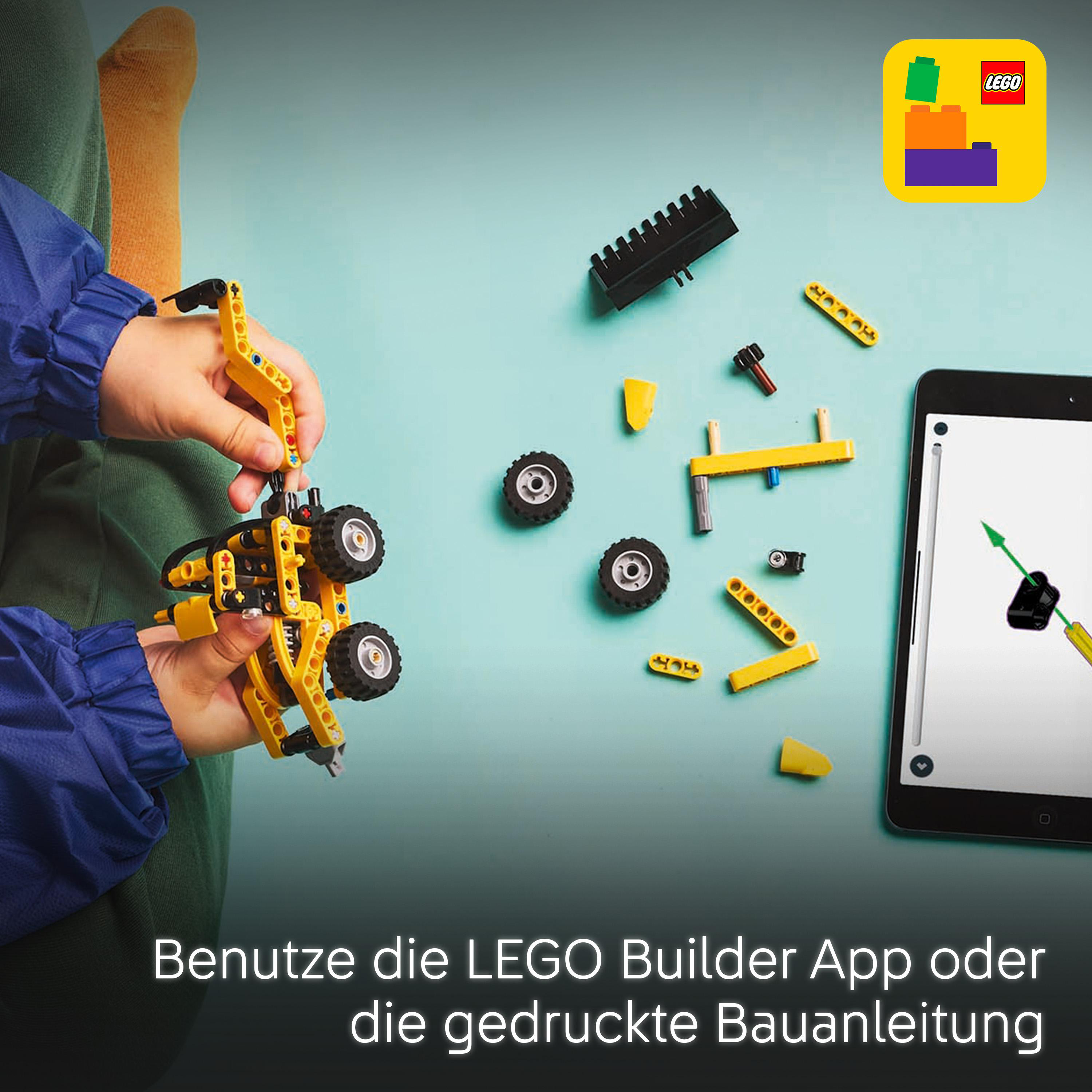 Kind baut gelbes LEGO Technic-Modell mit Anleitung auf Tablet. Verstreute Teile.