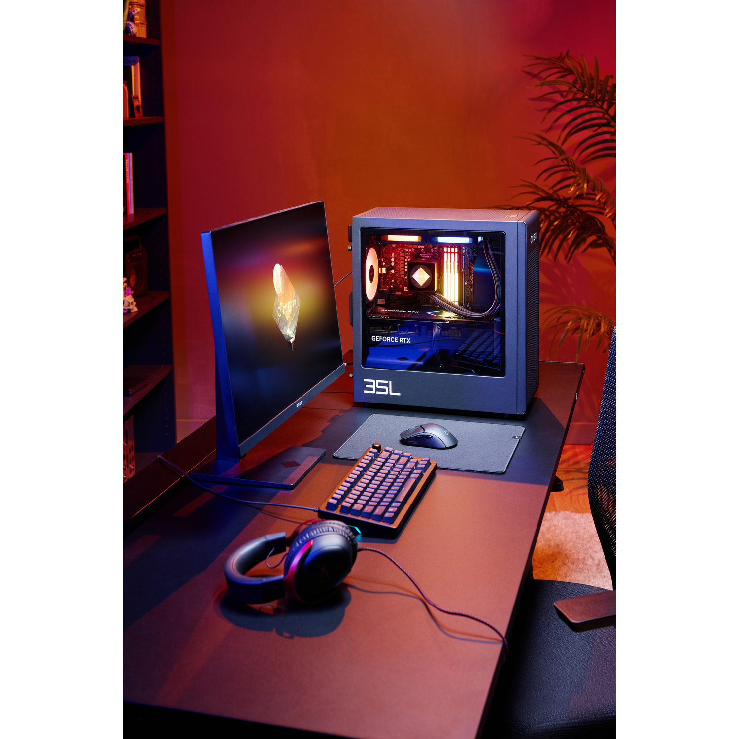 A gaming computer setup on a desk with monitor, keyboard, mouse, and headphones.