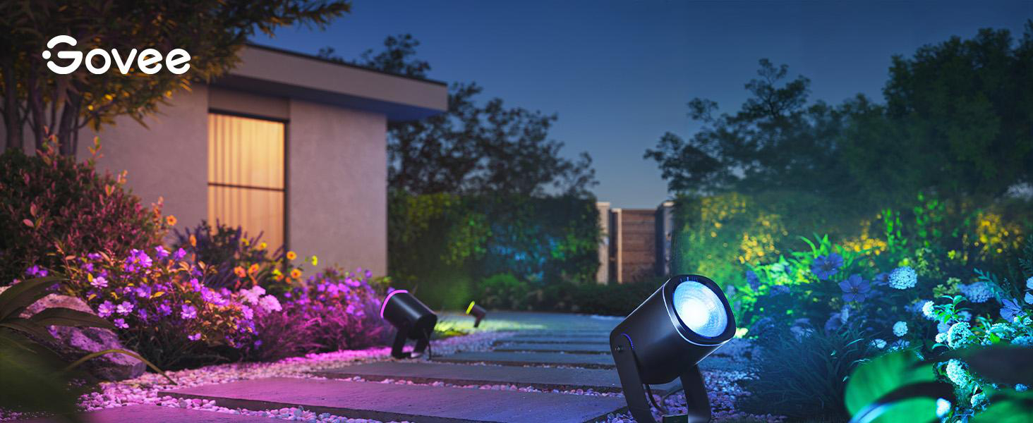 Govee-Lichter beleuchten einen Gartenweg in der Dämmerung in Lila- und Blautönen.