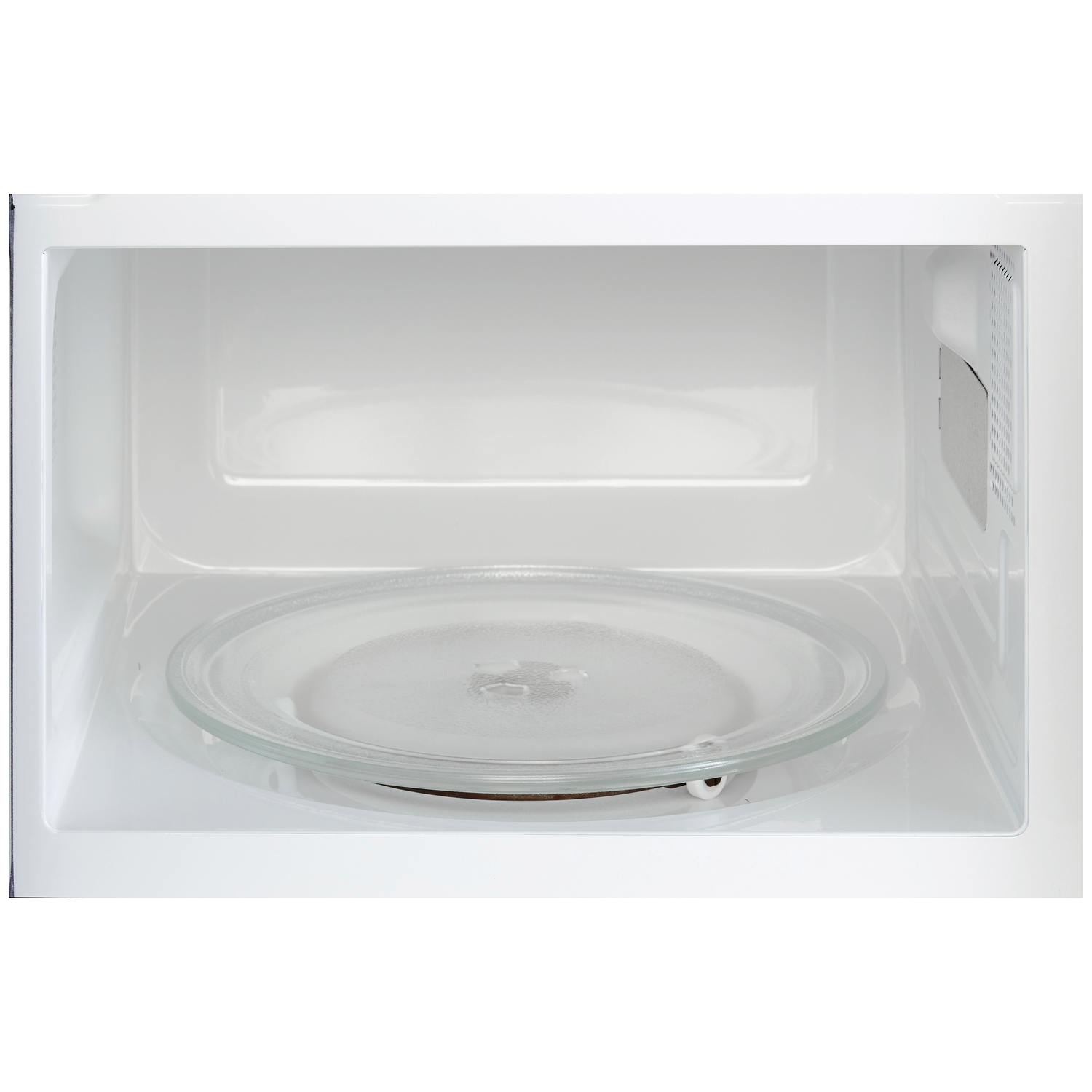 Binnenaanzicht van een witte magnetron met glazen draaiplateau.