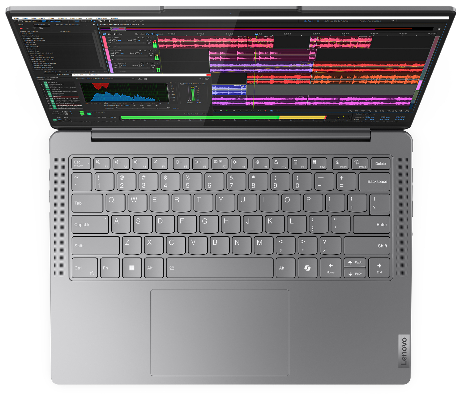 Un ordinateur portable gris est ouvert, affichant un logiciel de montage audio sur son écran.