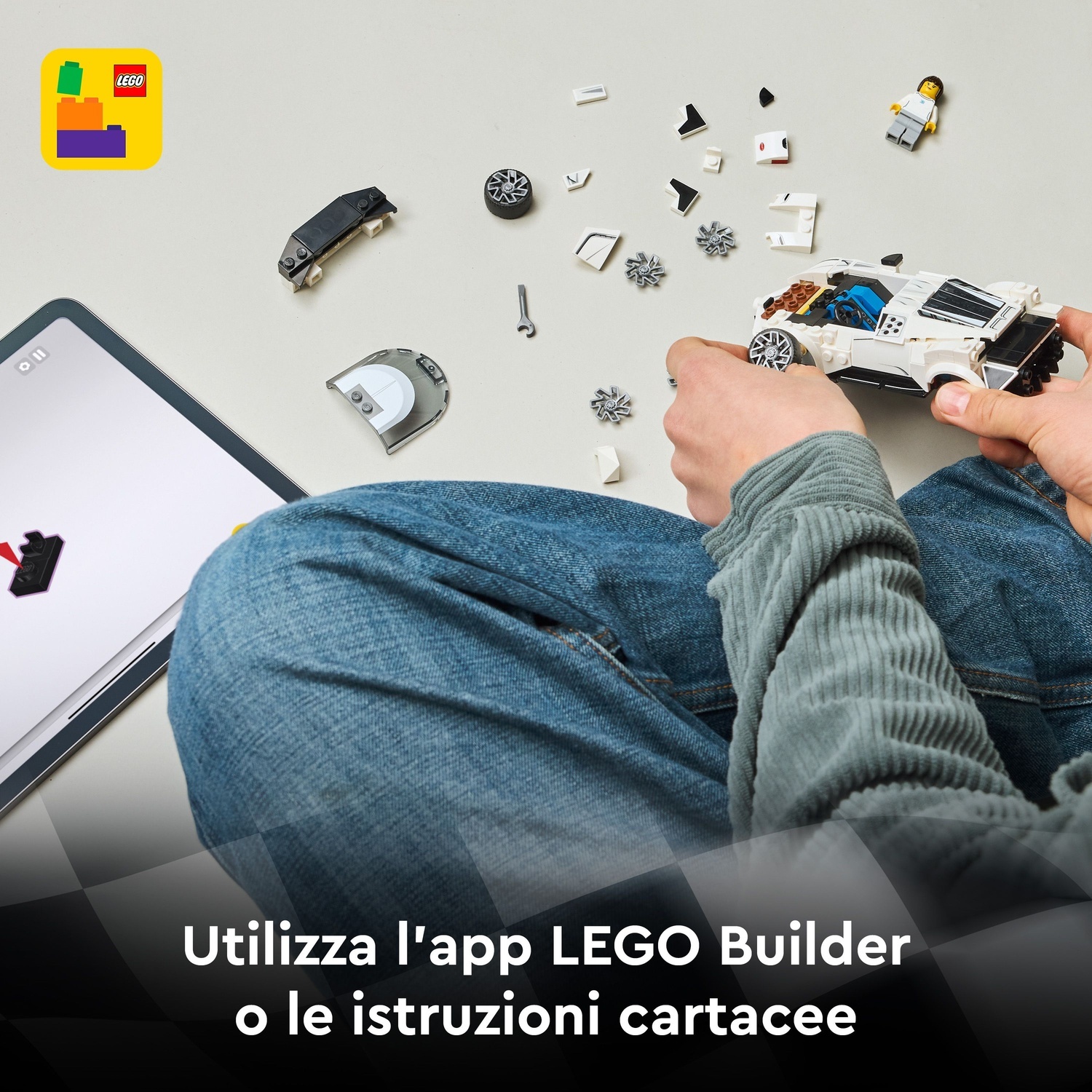 Bambino costruisce auto Lego con istruzioni su tablet e pezzi separati.