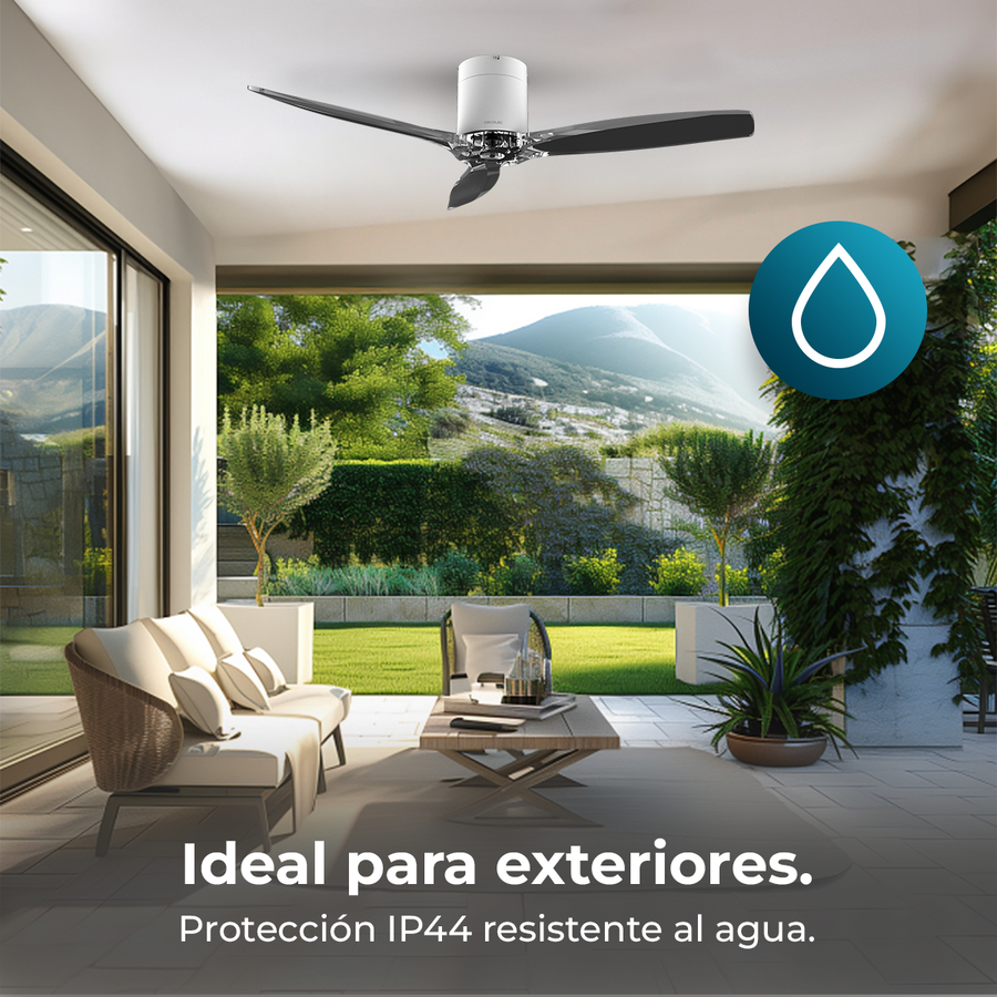 Terraza exterior con ventilador de techo, sofá, mesa de centro y vegetación.
