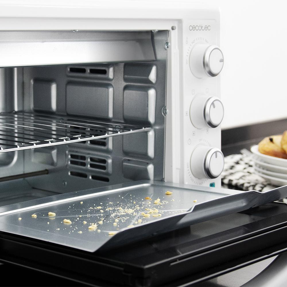 Horno blanco abierto Cecotec con bandeja con migas y rejilla.