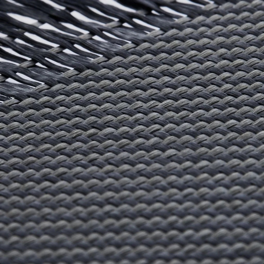 Wzorzysta tkanina w odcieniach szarości i czerni, z widoczną teksturą powierzchni.