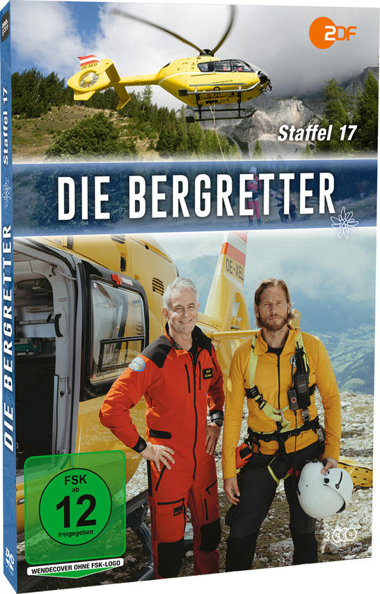 Zwei Bergretter stehen vor einem Hubschrauber. Ein gelber Hubschrauber fliegt darüber.