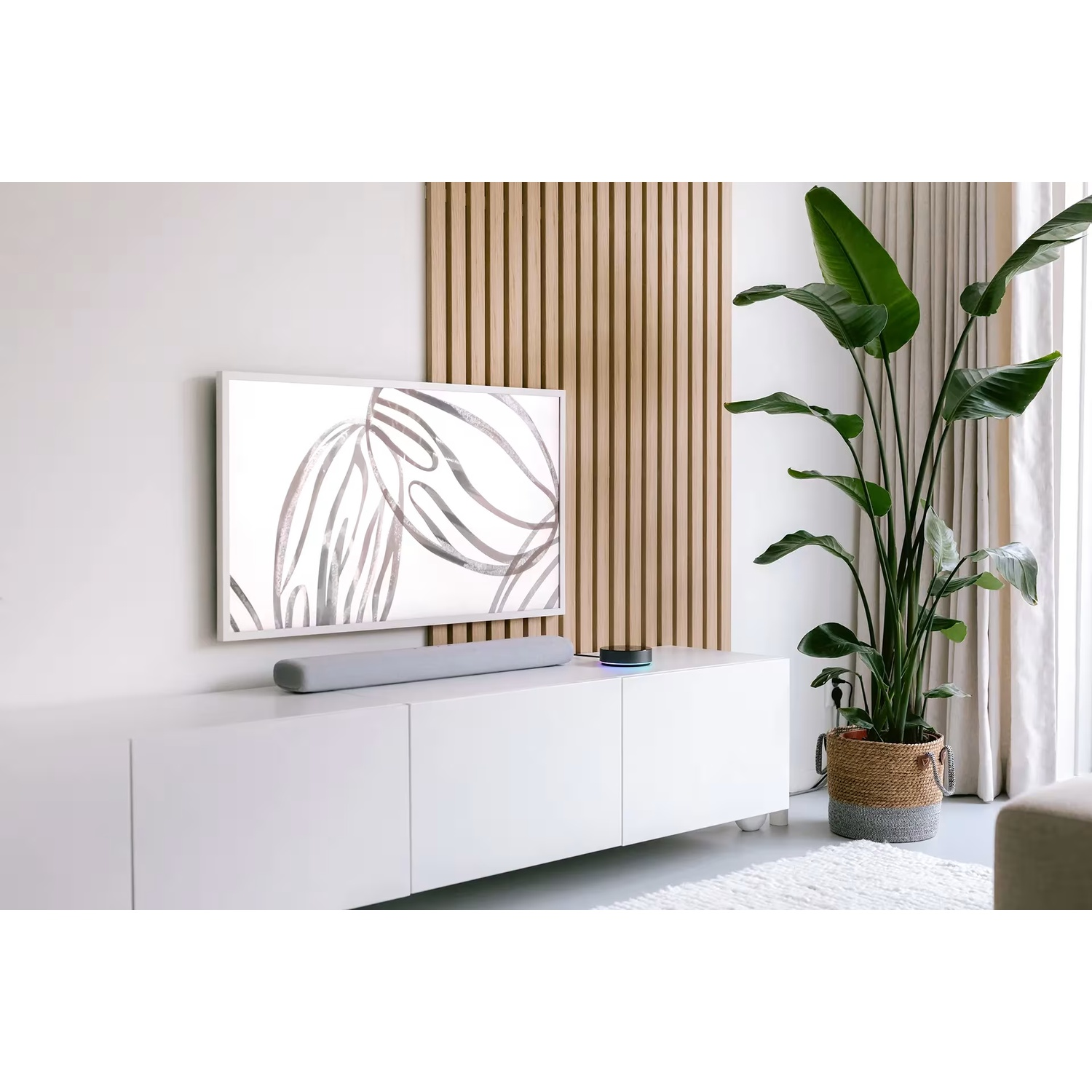 Modern living room with TV, soundbar, plant, and decor.