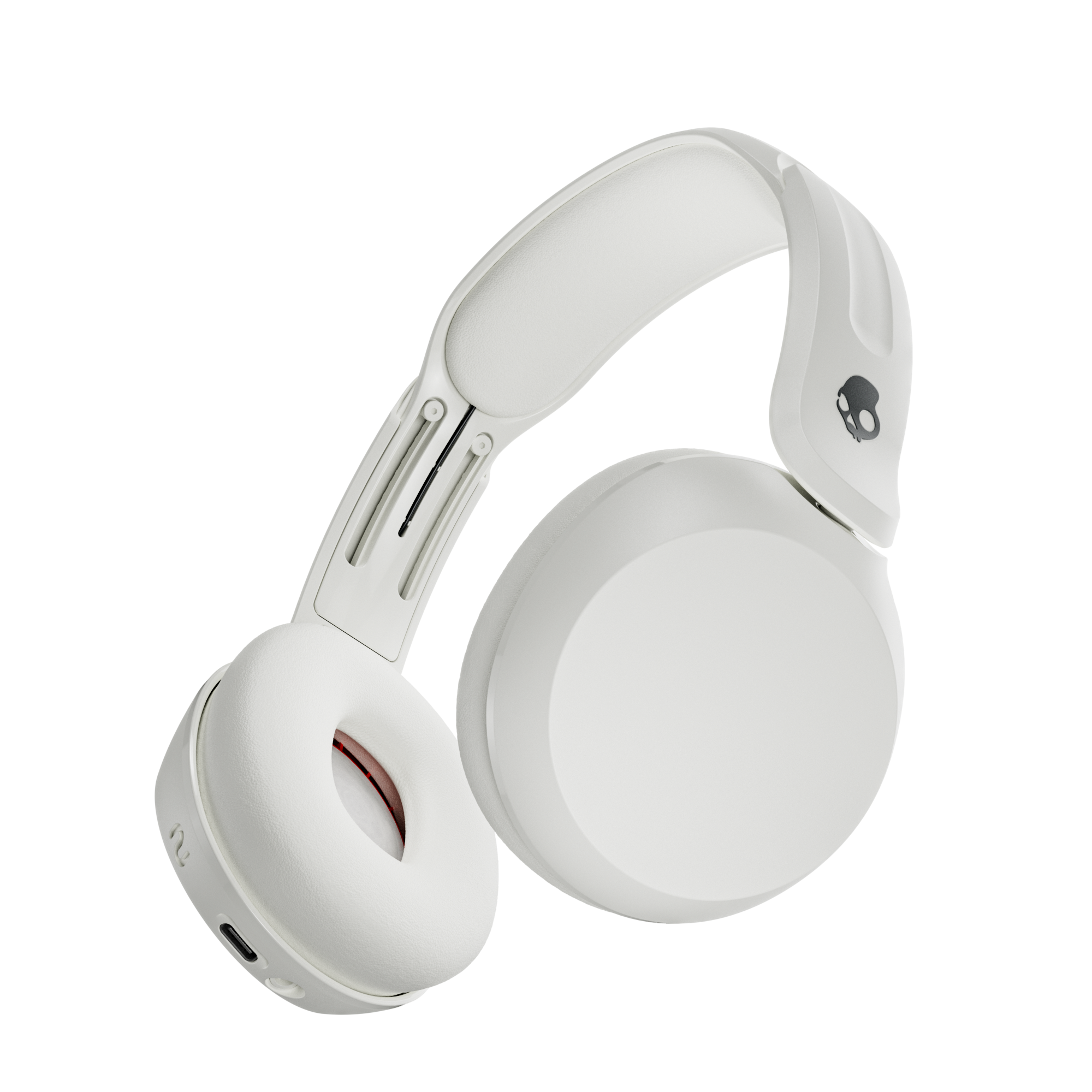 Weiße Skullcandy Kopfhörer mit schwarzem Totenkopf-Logo an der Ohrmuschel. Ein USB-C-Anschluss ist sichtbar.