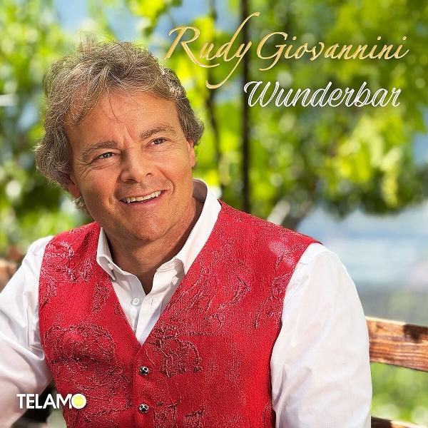 Mann in roter Weste und weißem Hemd lächelt. Schriftzug: Rudy Giovannini Wunderbar.