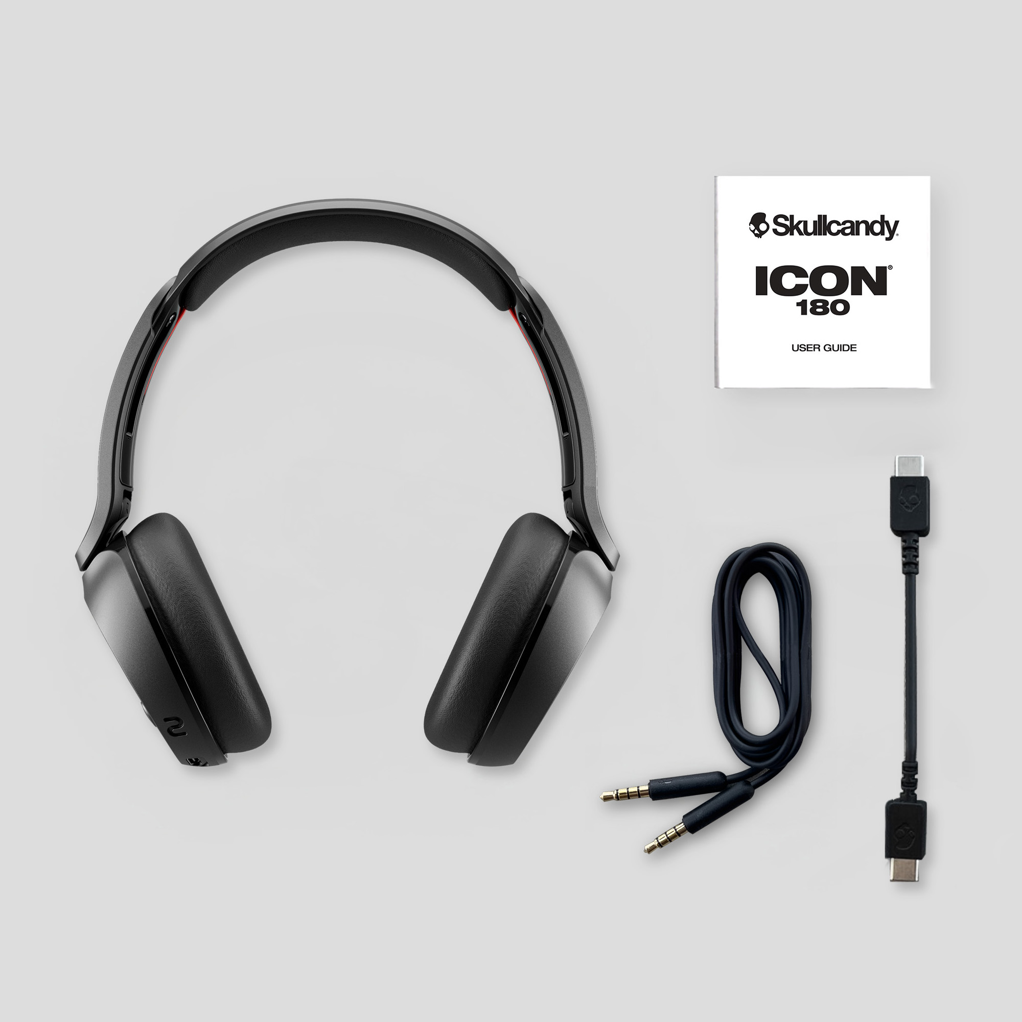 Schwarze Skullcandy Icon 180 Kopfhörer mit Benutzerhandbuch, Audiokabel und USB-C-Kabel.