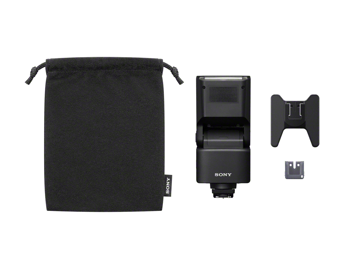 Schwarzer Sony Kamerablitz, Beutel und Zubehör auf weißem Hintergrund.