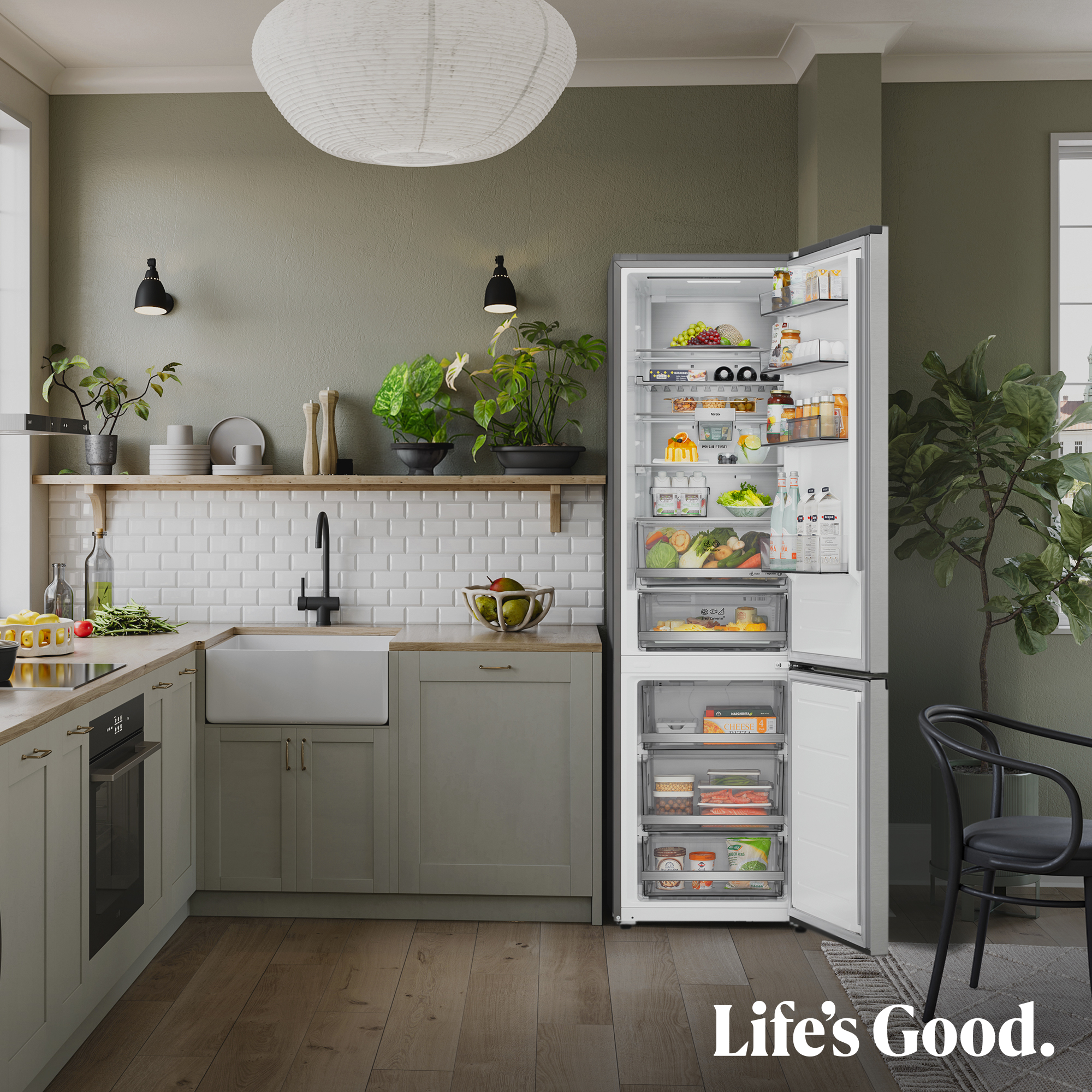Cocina moderna con nevera abierta, fregadero, horno, plantas y silla. "Life's Good."