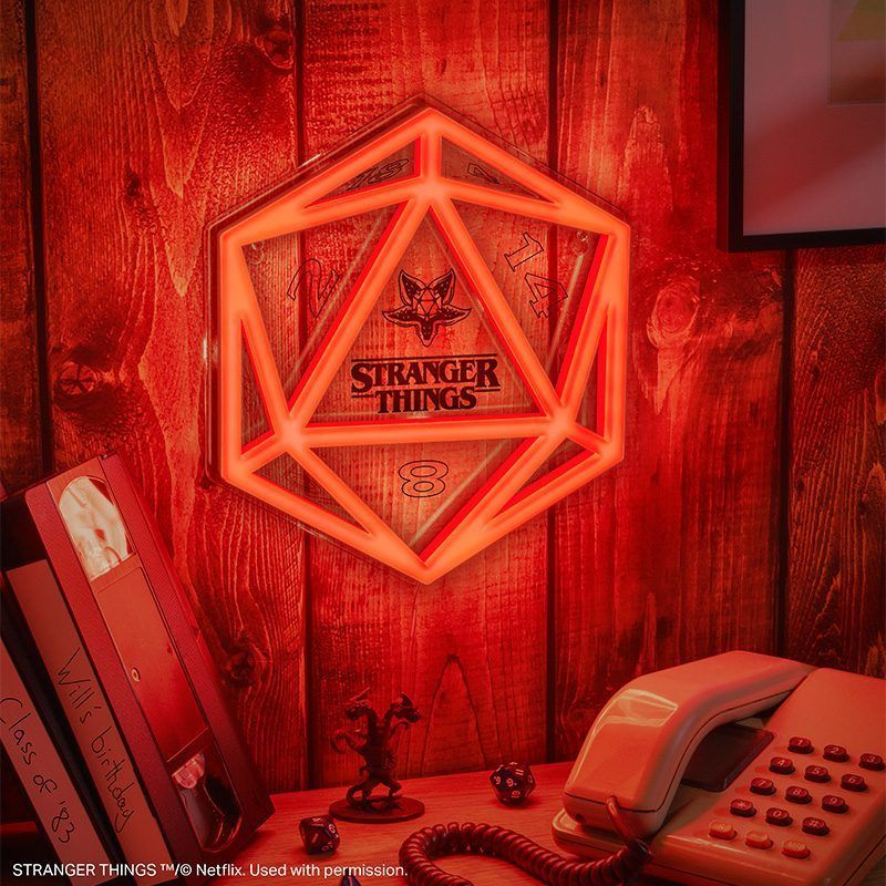 Stranger Things D20 neon tábla, VHS kazetták, telefon és kockák falon.