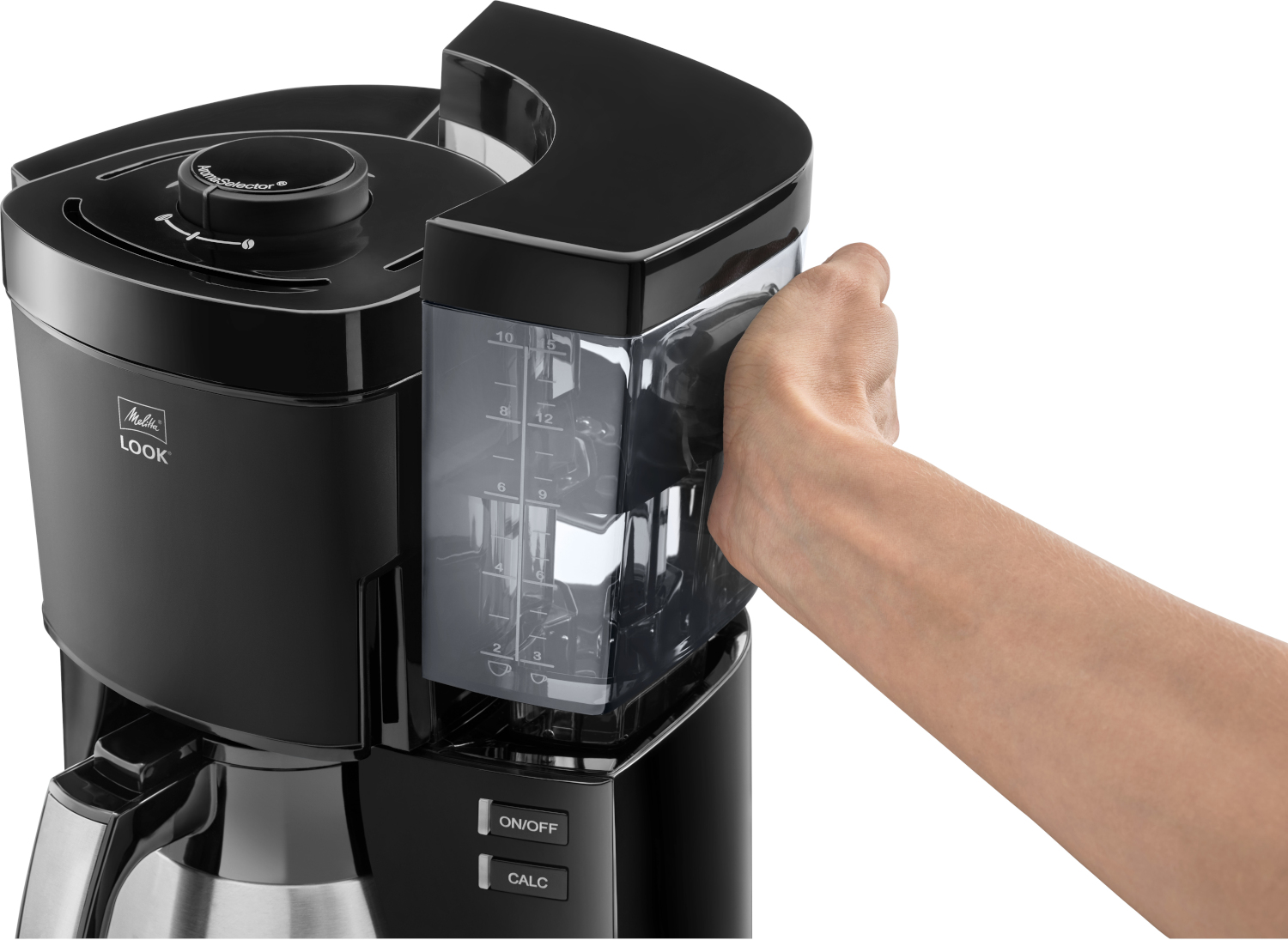 Une main retire le réservoir d'eau transparent d'une cafetière noire.