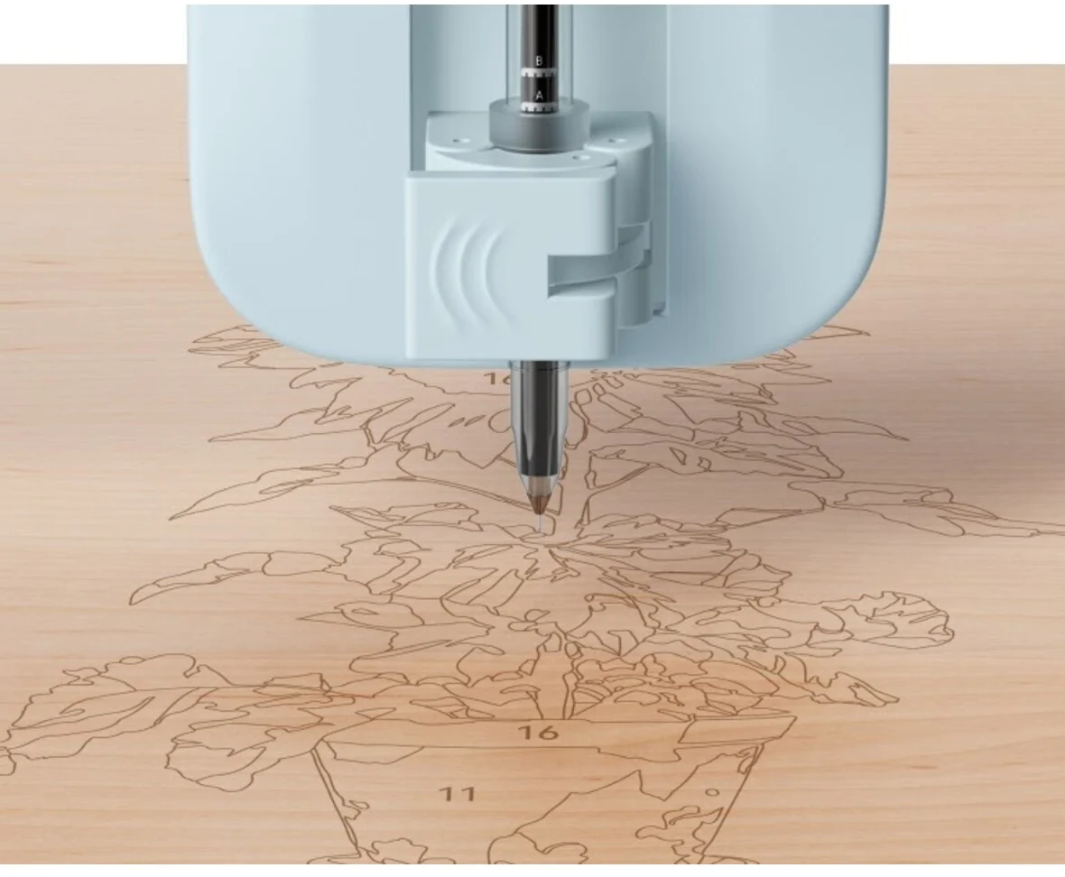 Una penna per macchine da taglio disegna sul legno, delineando una pianta in vaso con sezioni numerate.