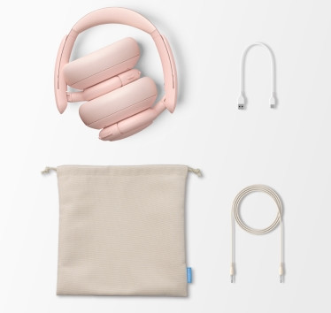 Różowe składane słuchawki, kabel do ładowania, kabel audio i etui na białym tle.