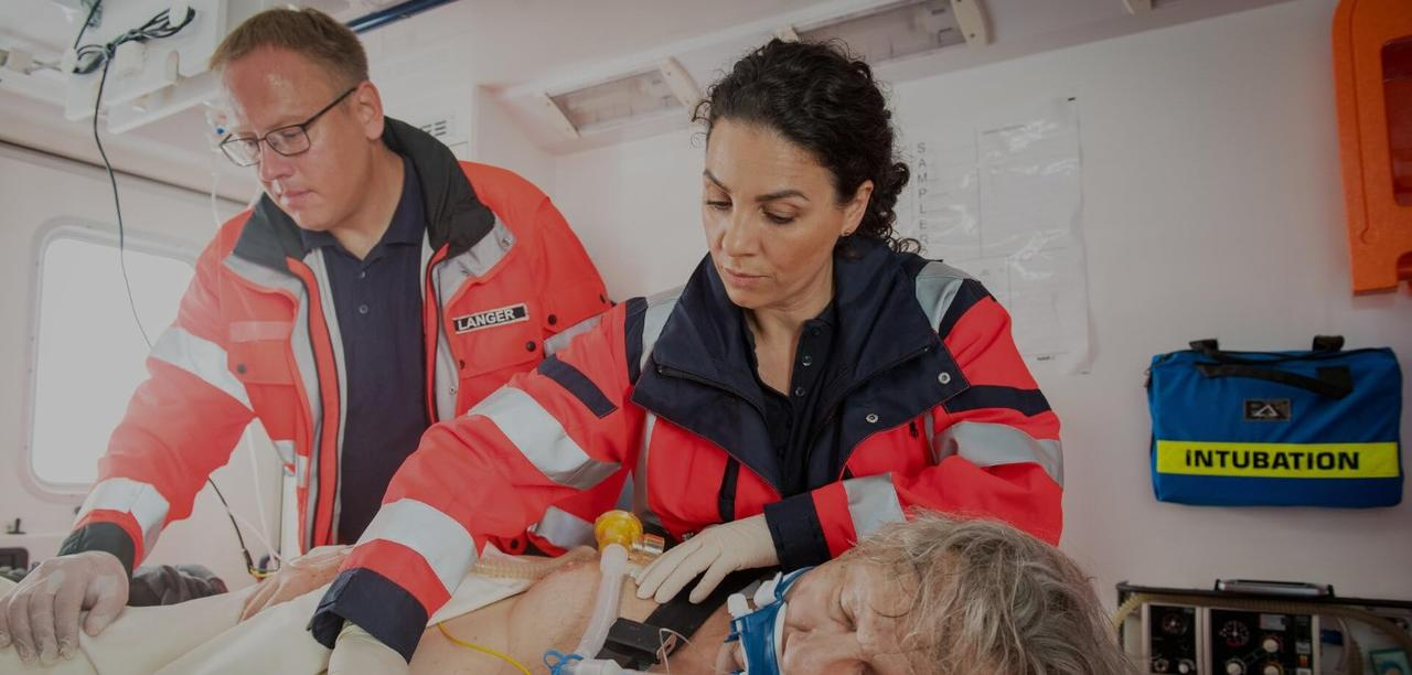 Rettungssanitäter versorgen einen Patienten im Krankenwagen, ein medizinischer Notfall.