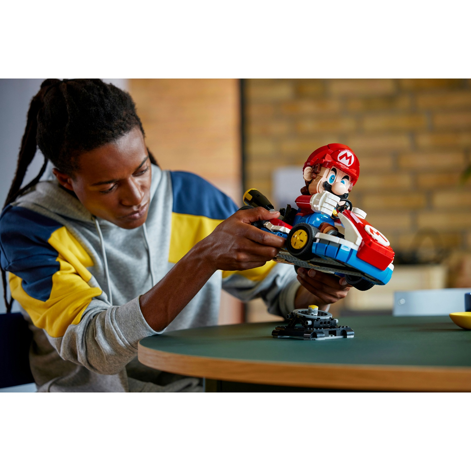Persona che tiene un Lego di Mario Kart, con un contatore di partenza sul tavolo.