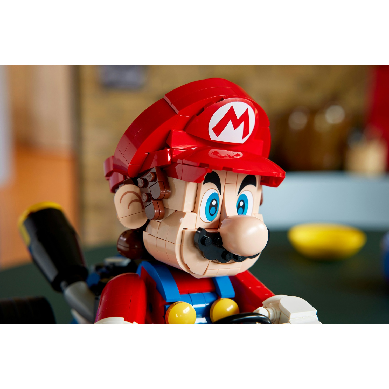 Un modello Lego di Mario guida un kart con salopette blu e camicia rossa.