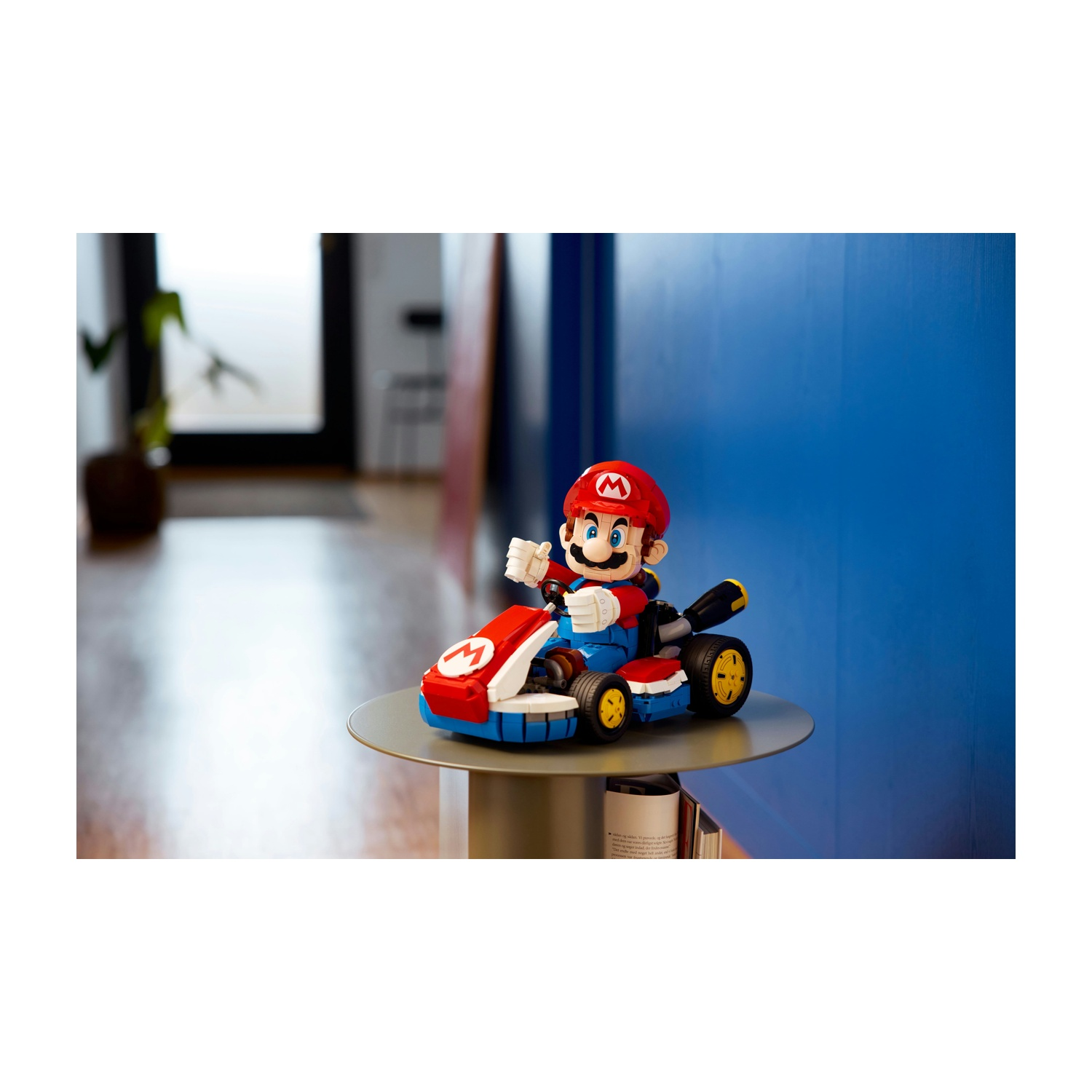 Mario siede nel suo go-kart rosso con accenti blu e bianchi su un tavolo.