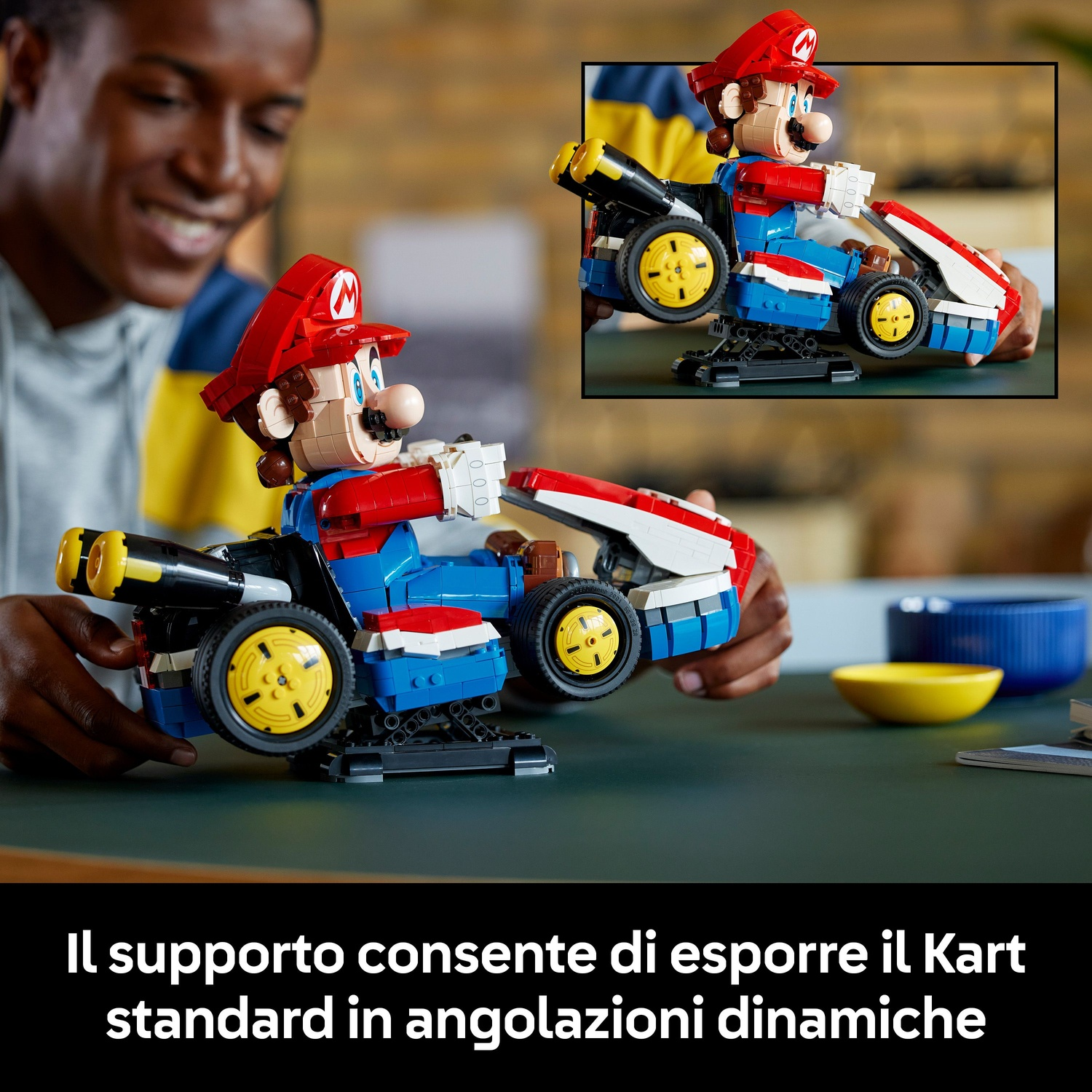 Un uomo sorride tenendo un'auto da corsa Lego Mario Kart. L'auto è blu, rossa e bianca.