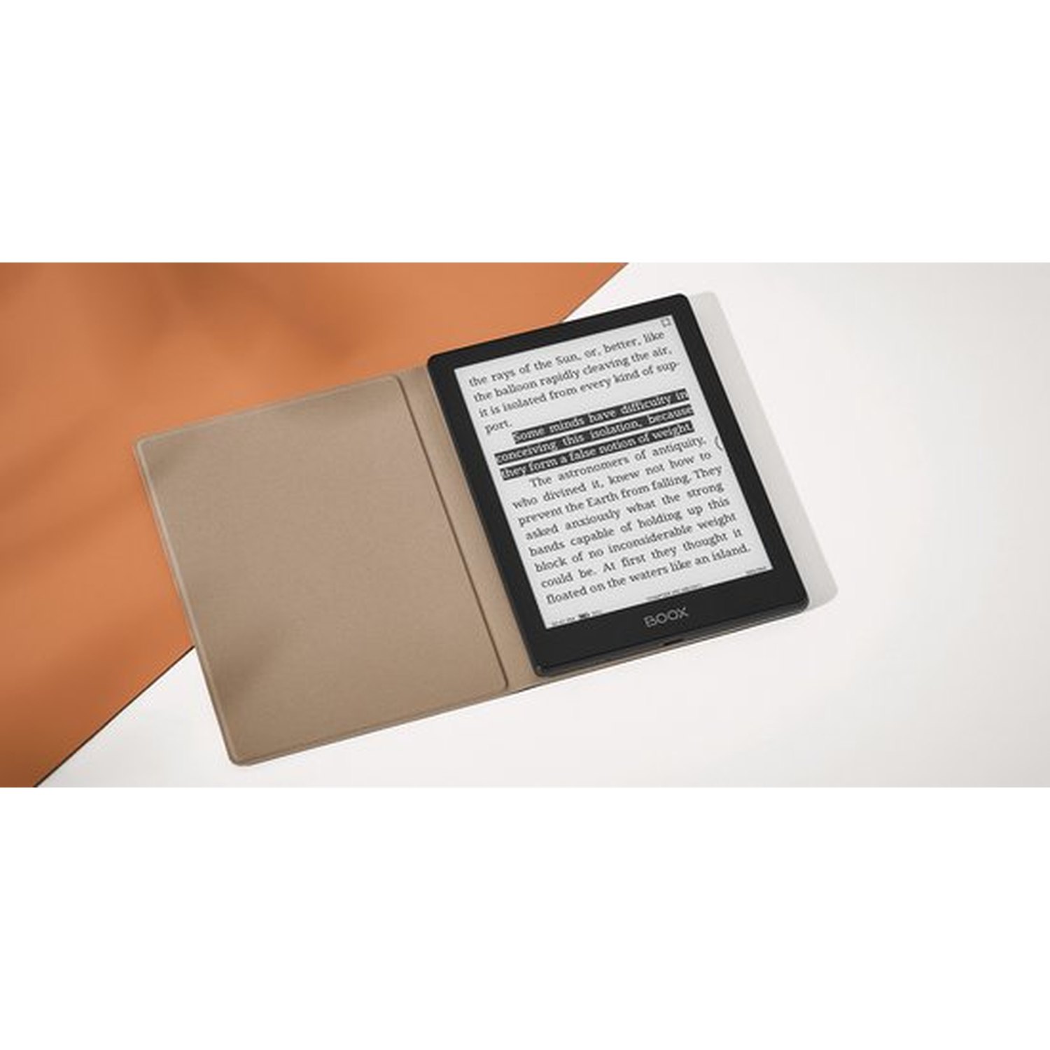 Een zwarte e-reader met een bruine hoes rust op een wit en oranje oppervlak.