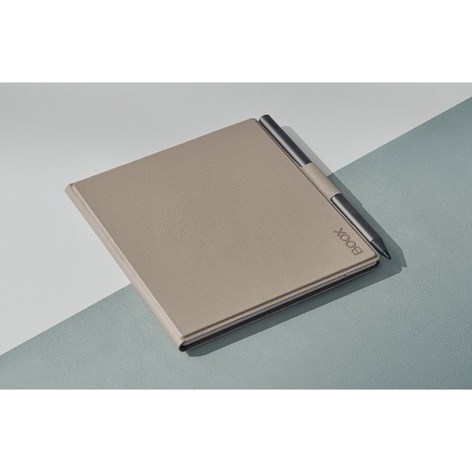 Een beige e-reader met stylus rust op een gesplitste achtergrond van wit en turquoise.