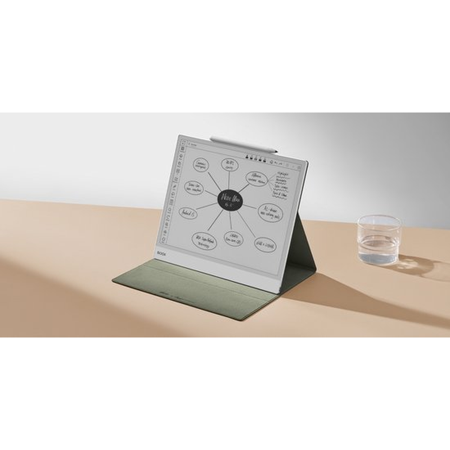 Een e-reader met pen en mindmap-notitie, op een tafel met een glas water.