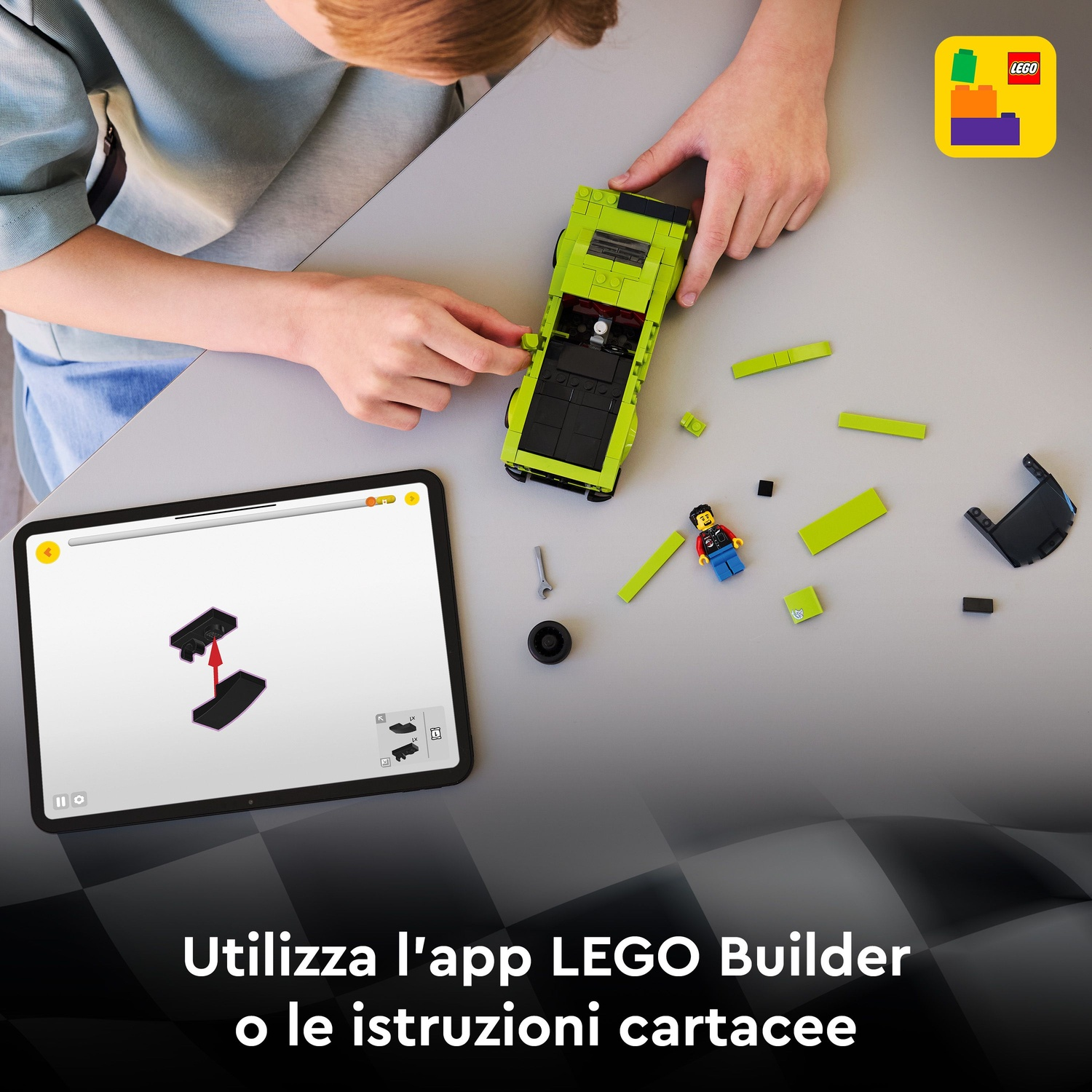 Un bambino costruisce un'auto Lego verde usando un'app su tablet e mattoncini Lego sparsi.