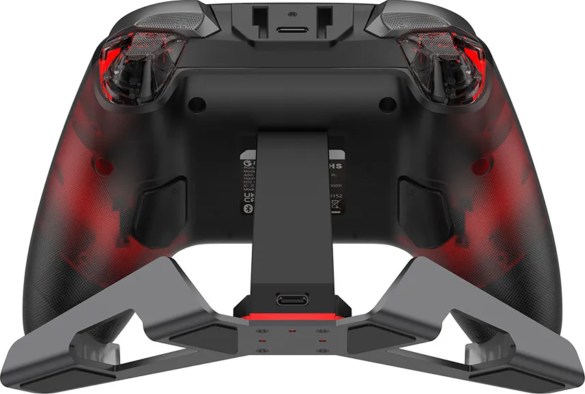 Controller da gioco nero con accenti rossi su supporto grigio. Vista posteriore.