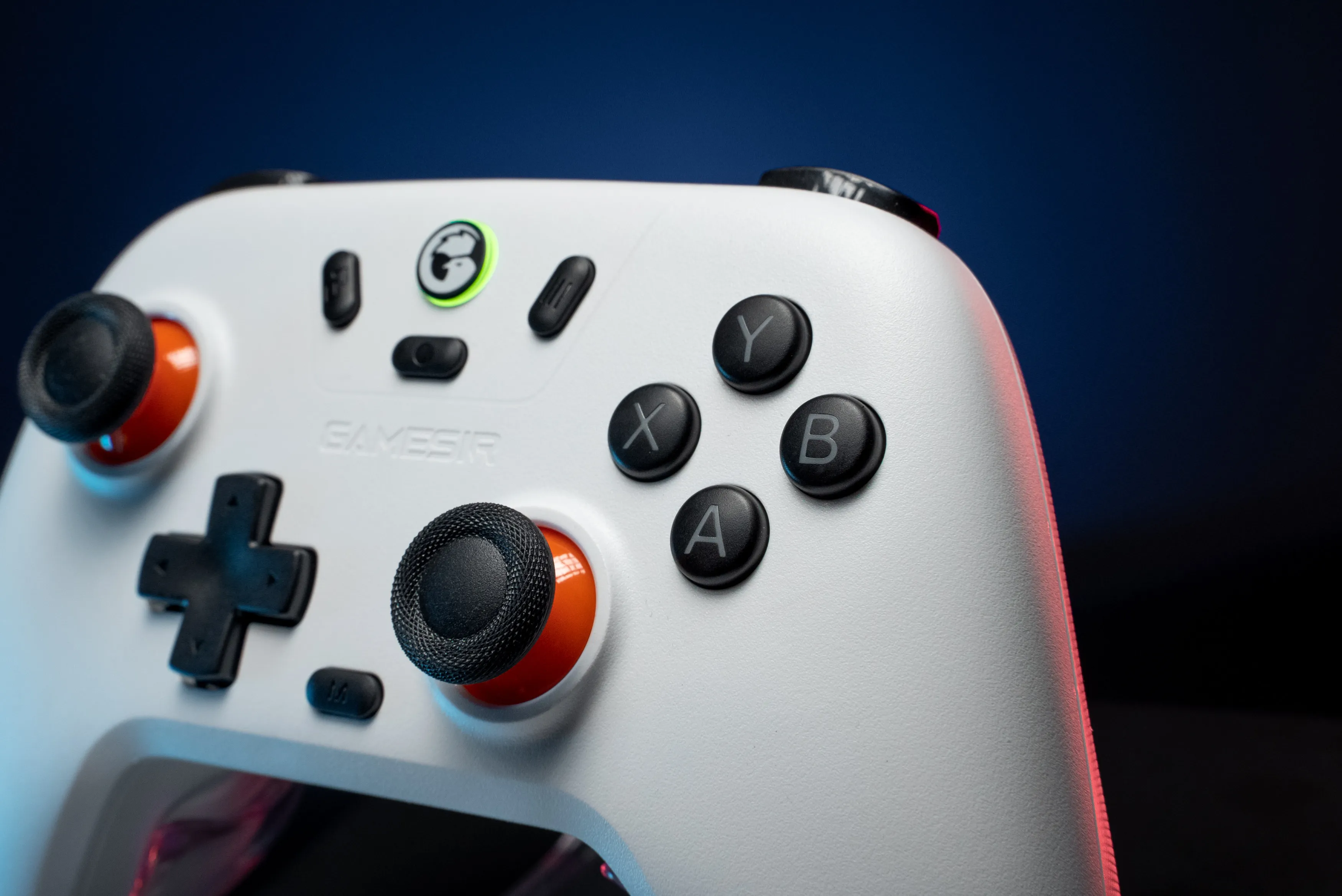Manette blanche avec boutons noirs et accents orange sur fond bleu foncé.