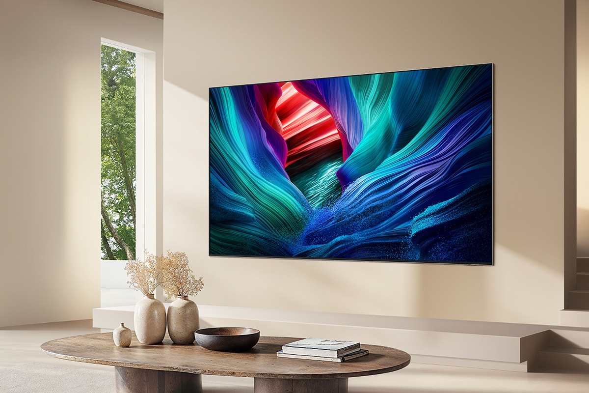 Une grande télévision affiche une image abstraite et colorée sur un mur.