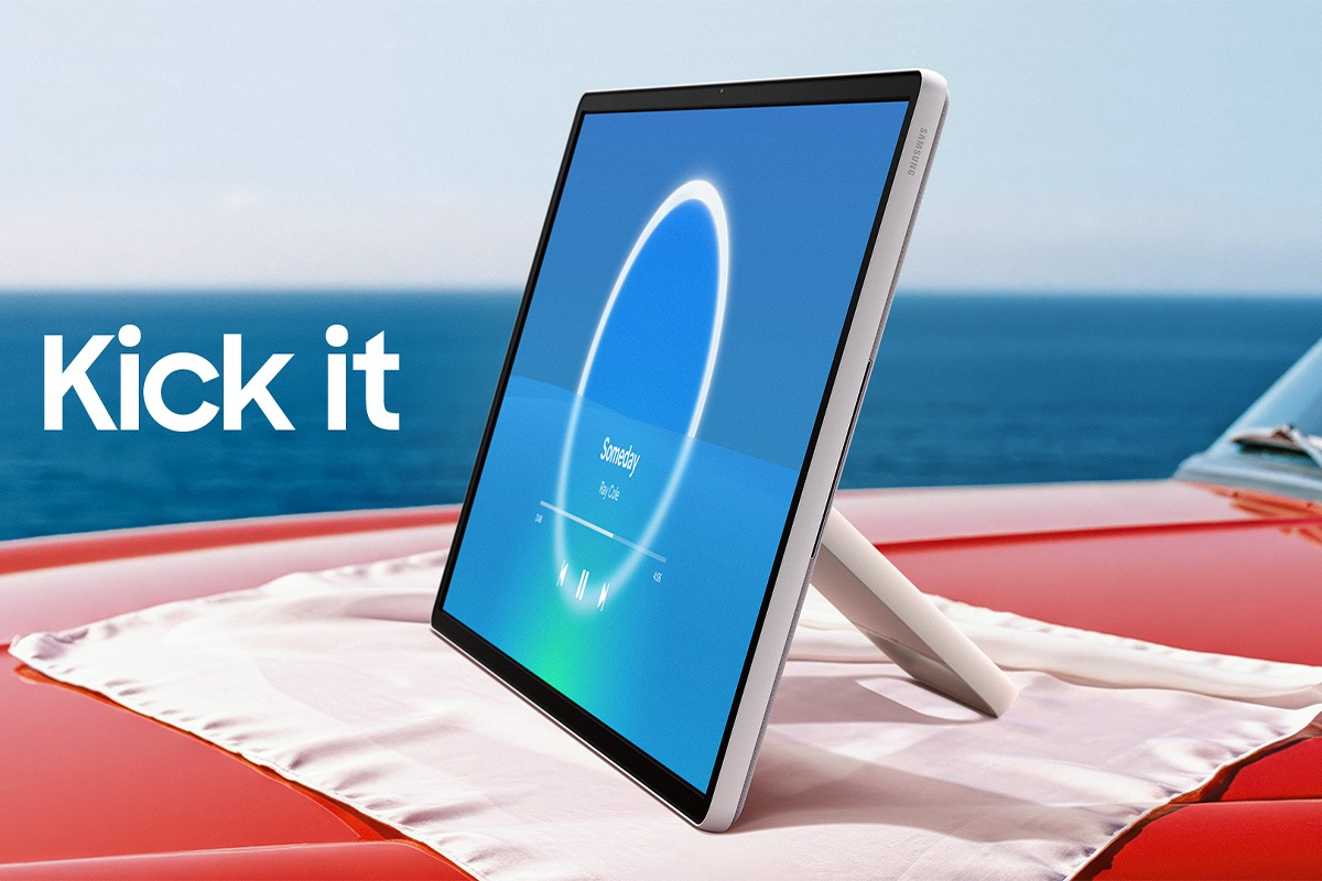 Un tablet mostra un lettore musicale su un'auto rossa vicino all'oceano. Testo: Kick it.