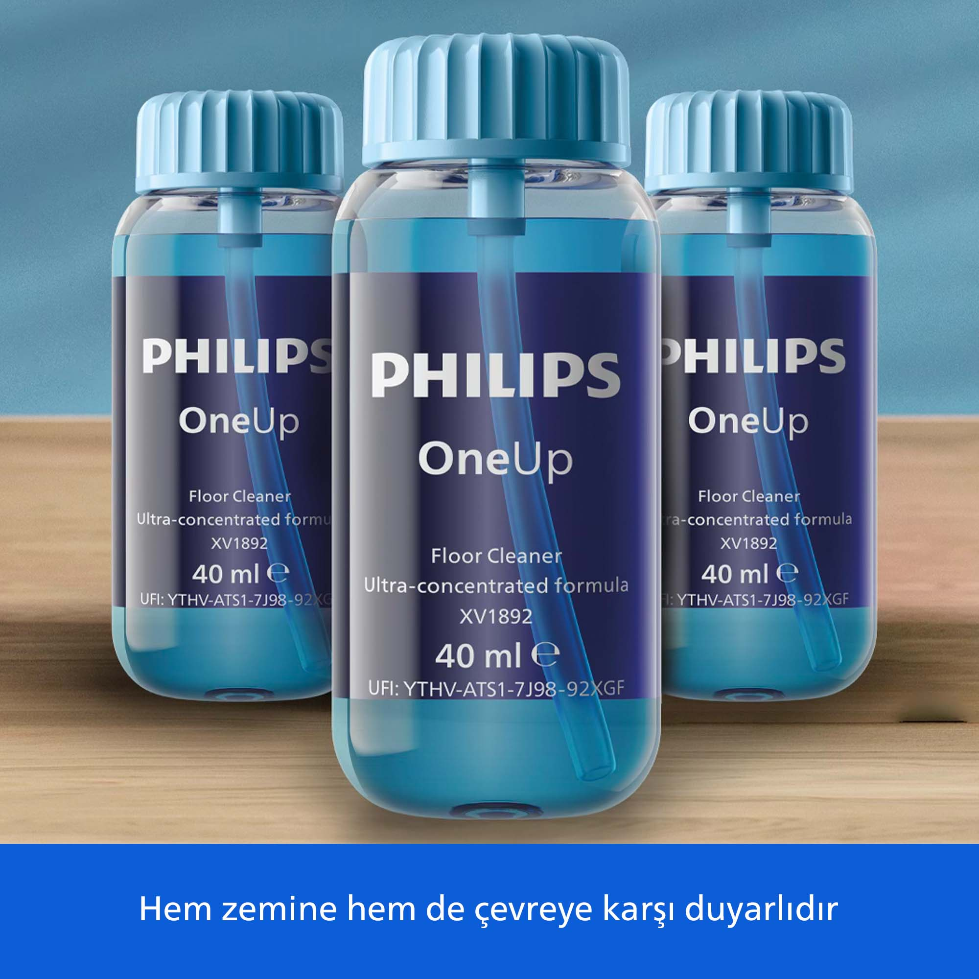 Mavi kapaklı ve etiketli üç Philips OneUp yer temizleyici şişesi.