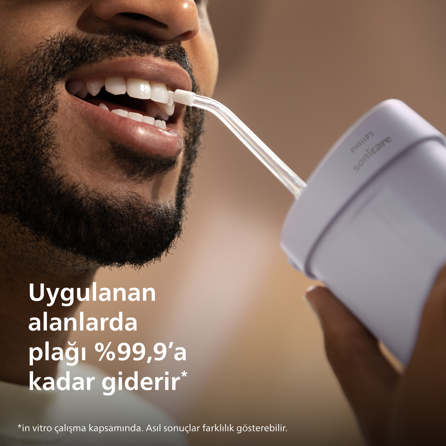 Adam diş temizliği için Philips Sonicare kullanıyor. Mor cihaz.
