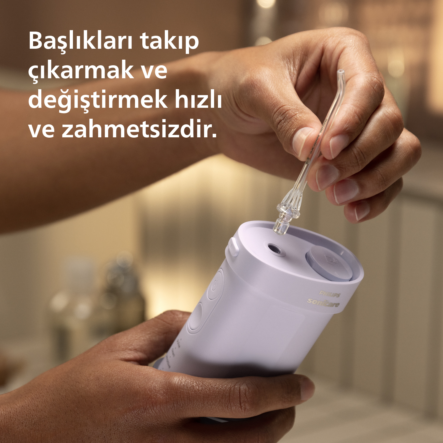 Bir el, Philips Sonicare diş ipi tutuyor ve başlığı takıyor.