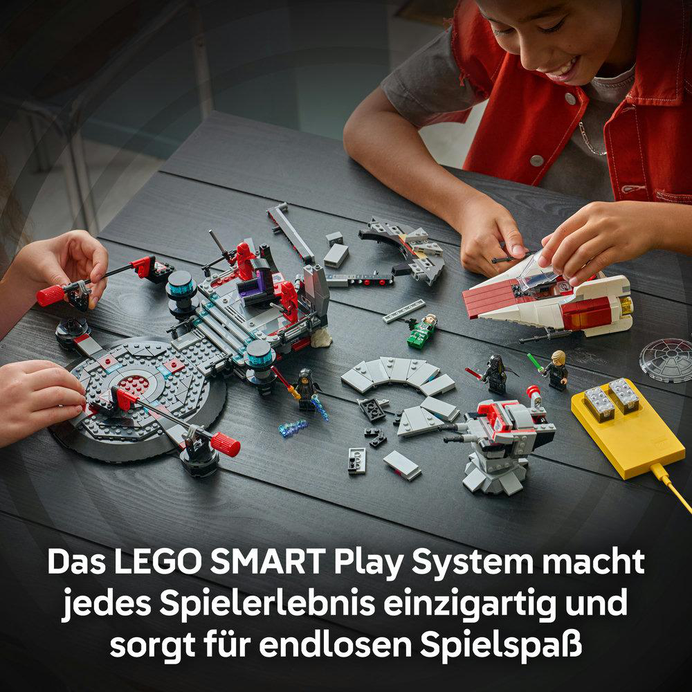 Zwei Kinder spielen mit LEGO Star Wars Sets auf einem dunklen Holztisch.