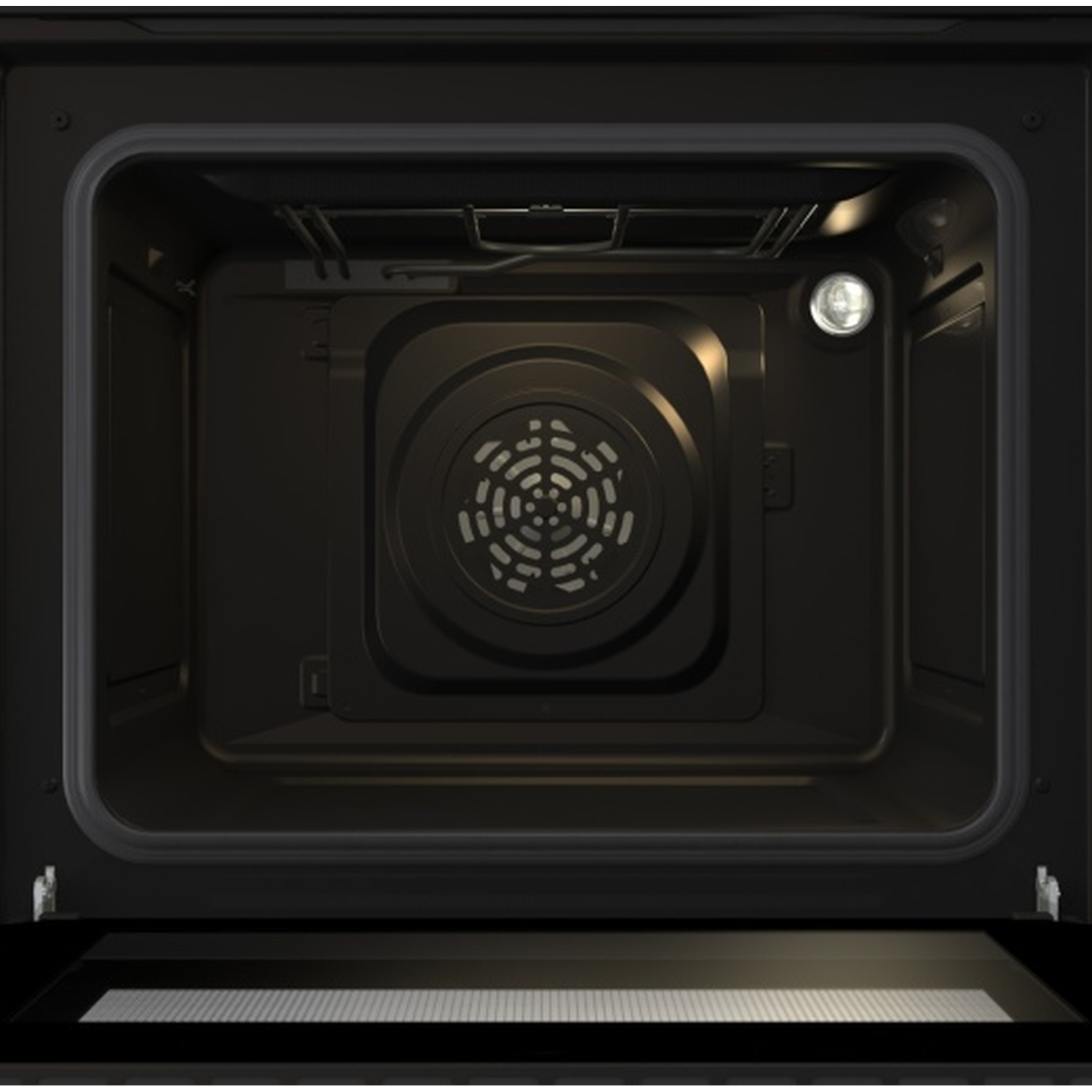 Interno di un forno scuro con ventola e luce.