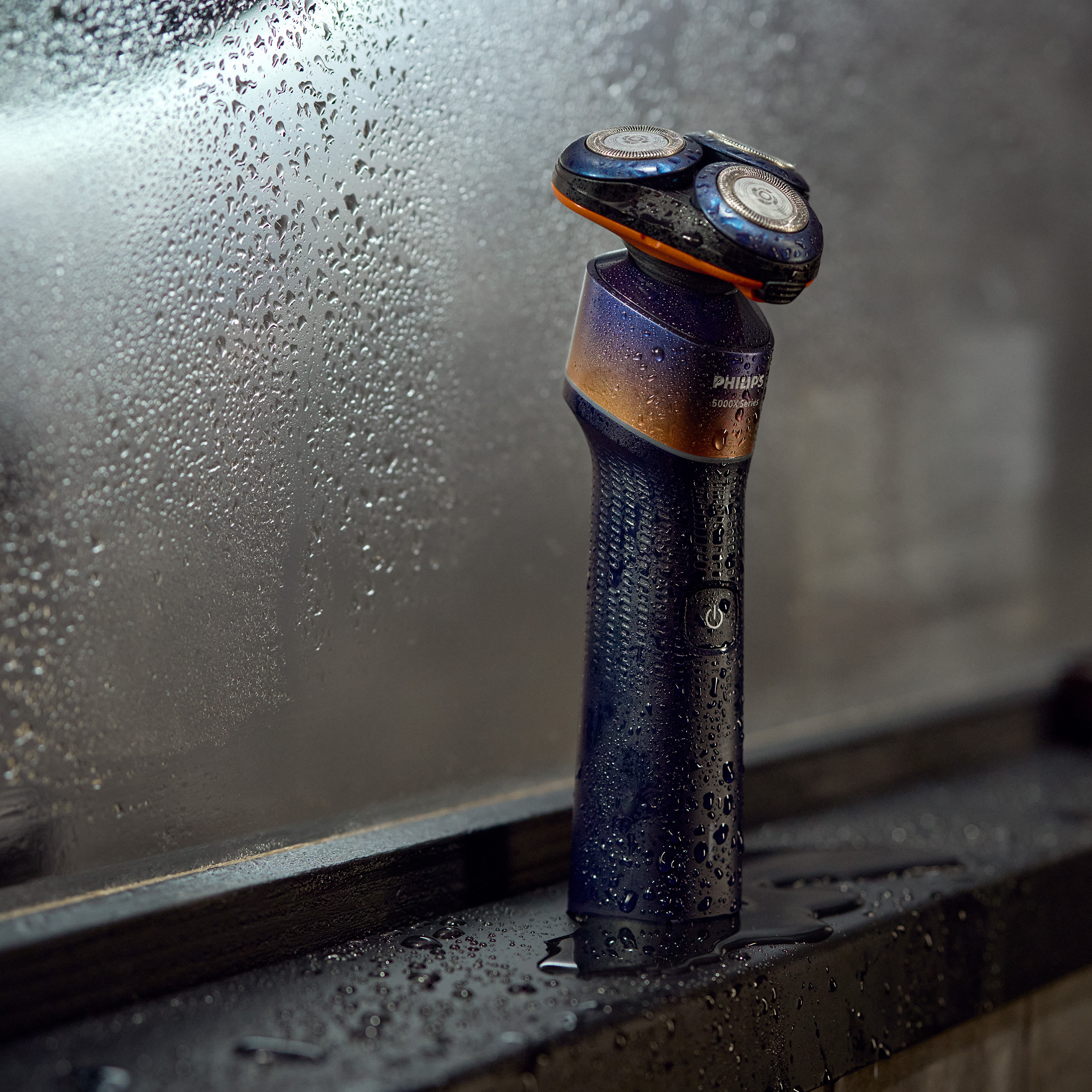 Mokry golarka elektryczna z trzema głowicami stoi na ciemnej powierzchni.