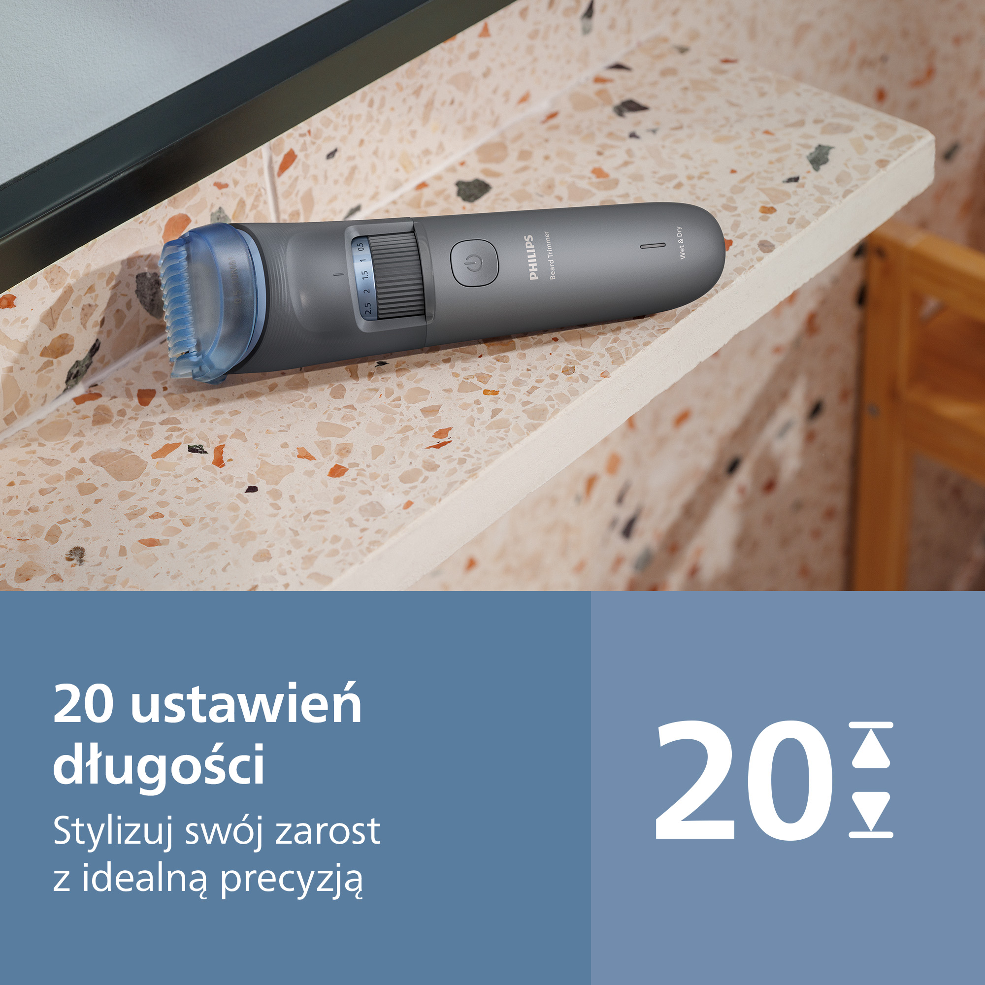 Szara maszynka do brody Philips z niebieską nasadką leży na kamiennej powierzchni.