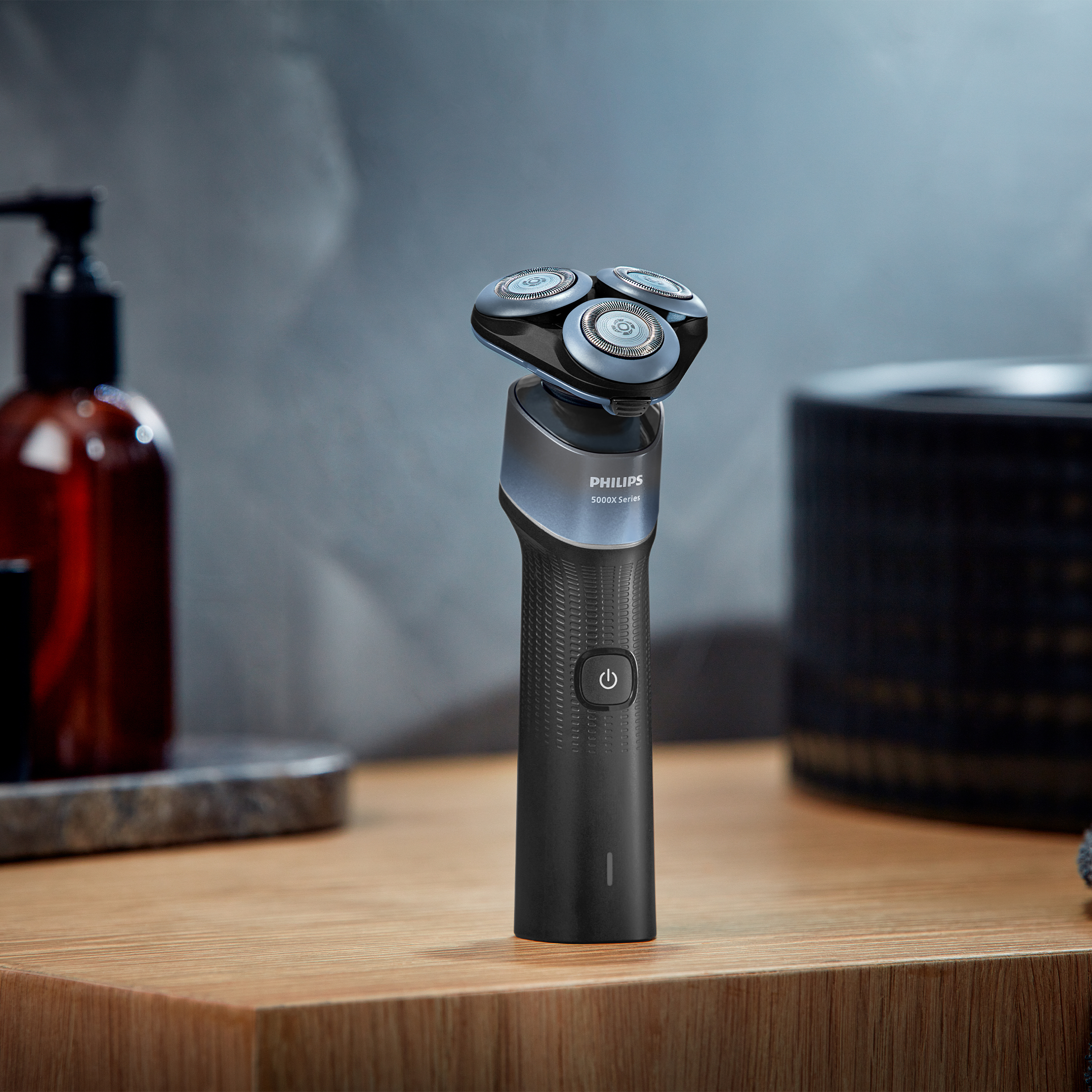 Czarna maszynka do golenia Philips z trzema obrotowymi głowicami na drewnianej powierzchni.