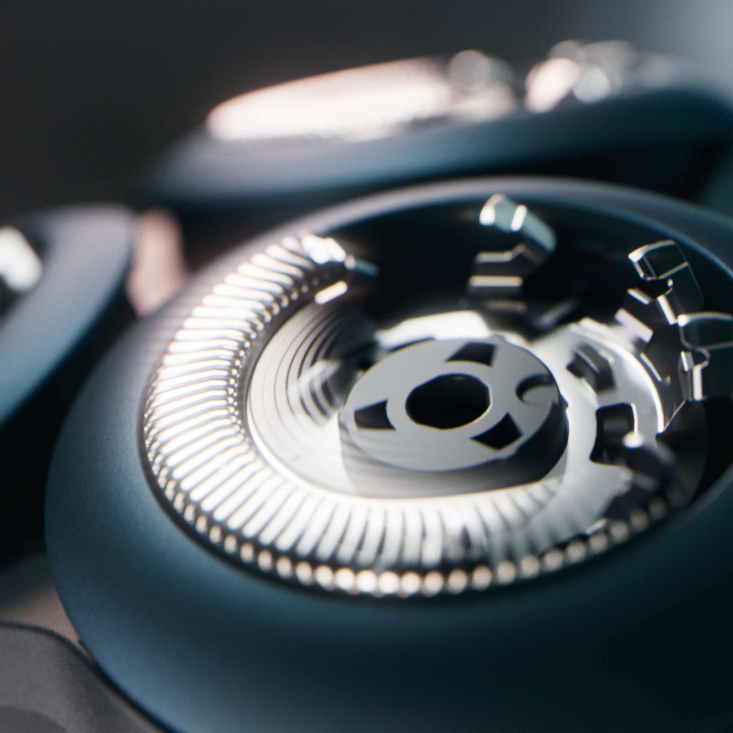 Zbliżenie głowicy golarki z metalowymi, zębatymi elementami w ciemnych odcieniach.
