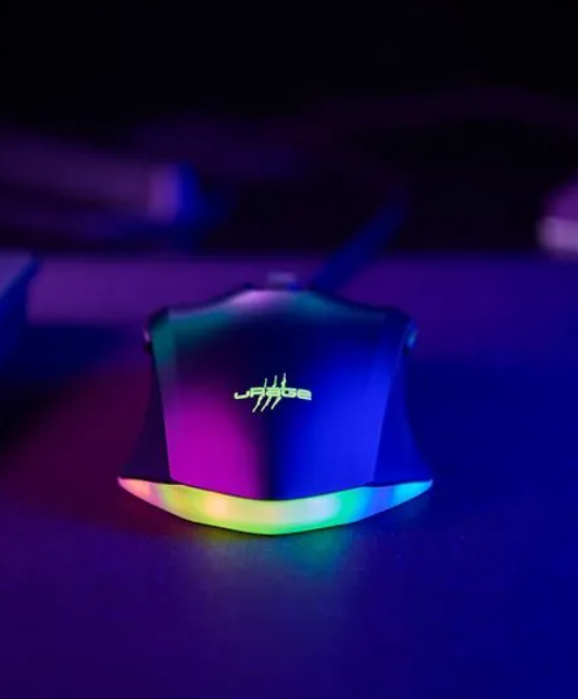 Eine schwarze Gaming-Maus mit RGB-Beleuchtung auf einem dunklen Schreibtisch.