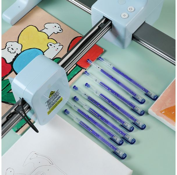 Un plotter da taglio con penne blu accanto e un disegno.
