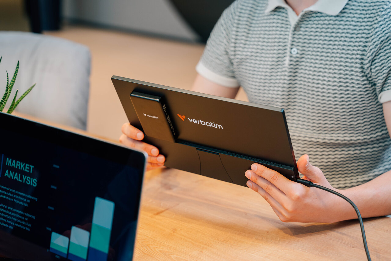 Une personne tient un moniteur portable noir avec le logo Verbatim.