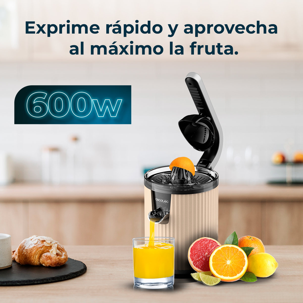 Un exprimidor eléctrico extrae jugo de una naranja. Hay cítricos cerca.