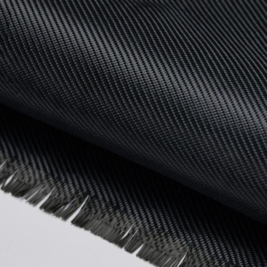 Szara tkanina węglowa z widocznym splotem i postrzępionymi krawędziami.
