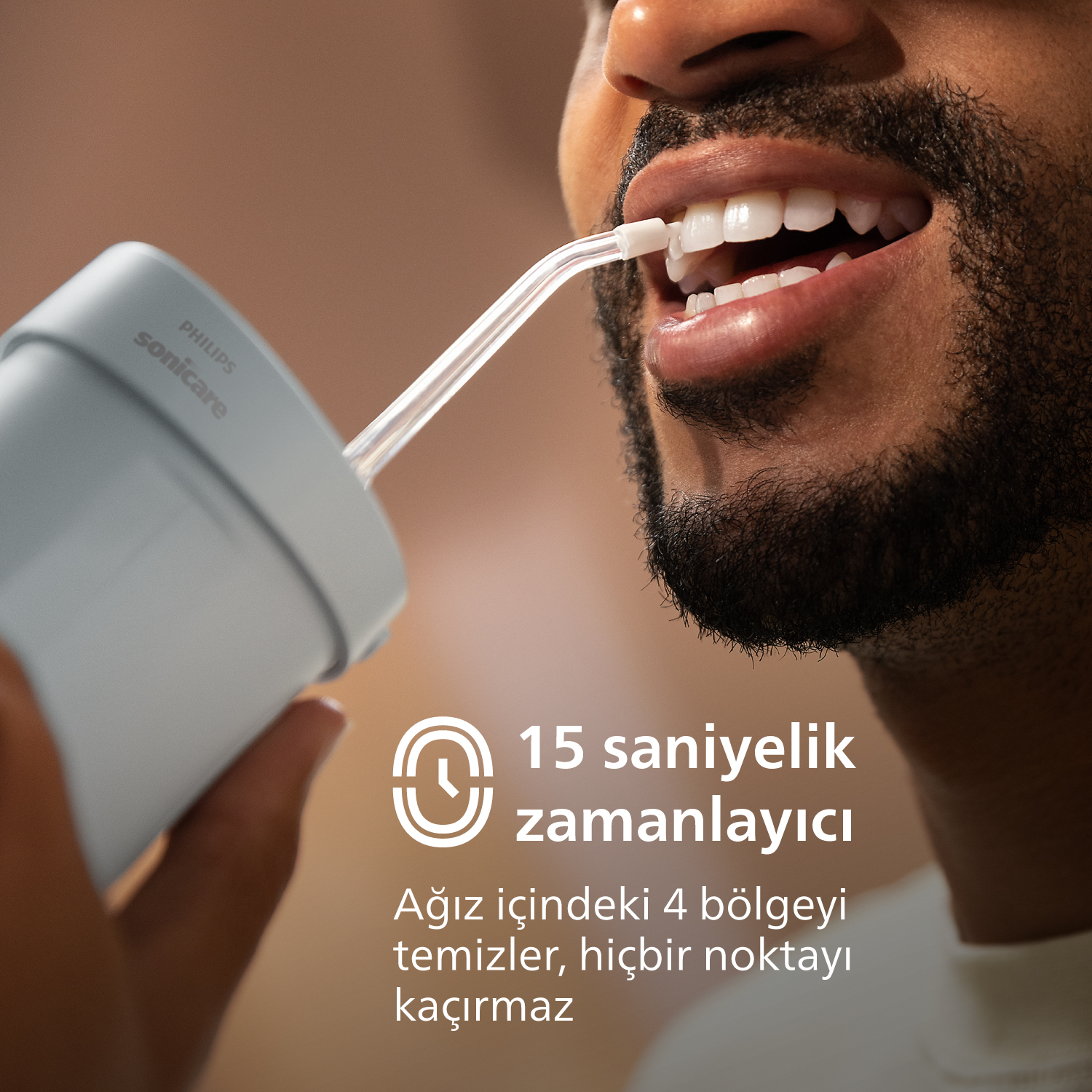 Adam diş temizliği için Philips Sonicare su jeti kullanıyor.