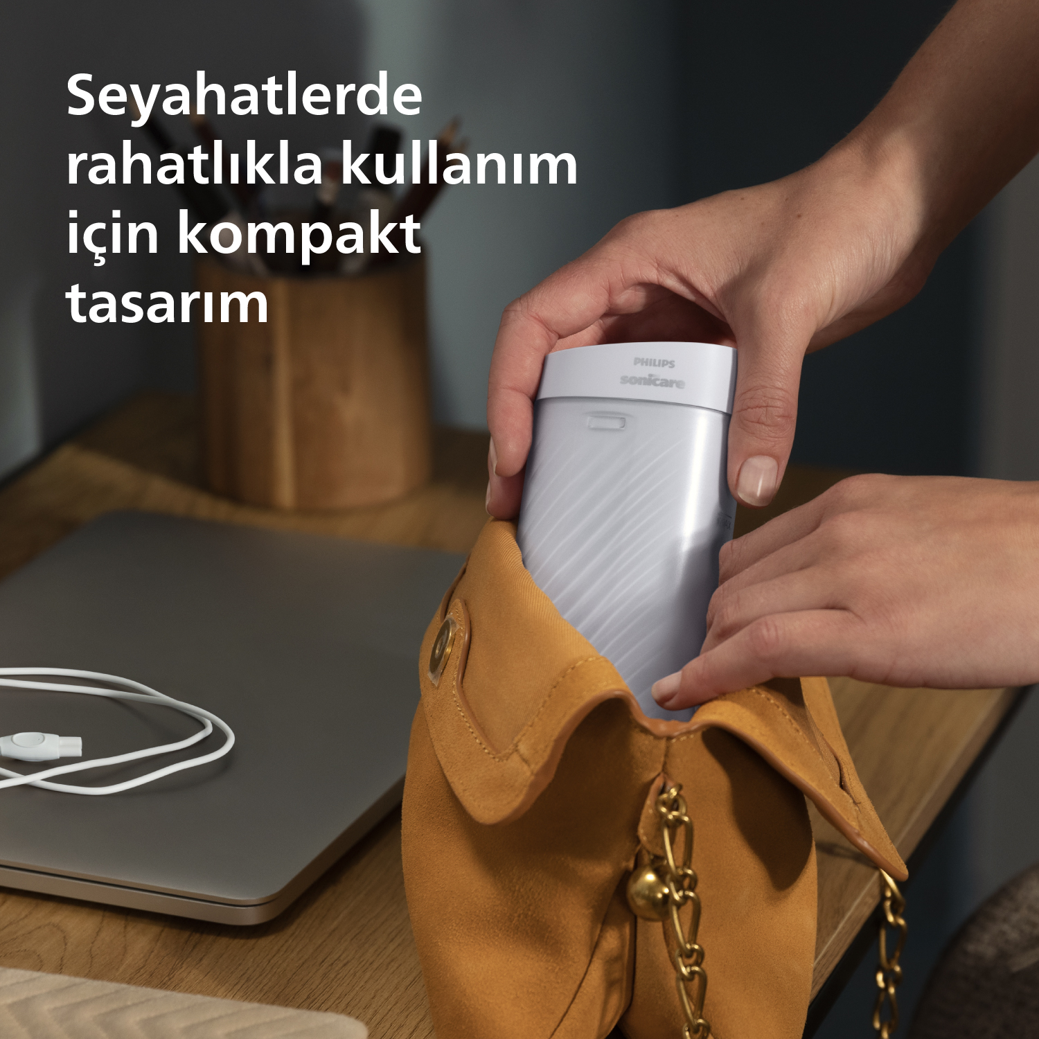 Bir el, beyaz bir Philips Sonicare tıraş makinesini kahverengi bir çantaya koyuyor.