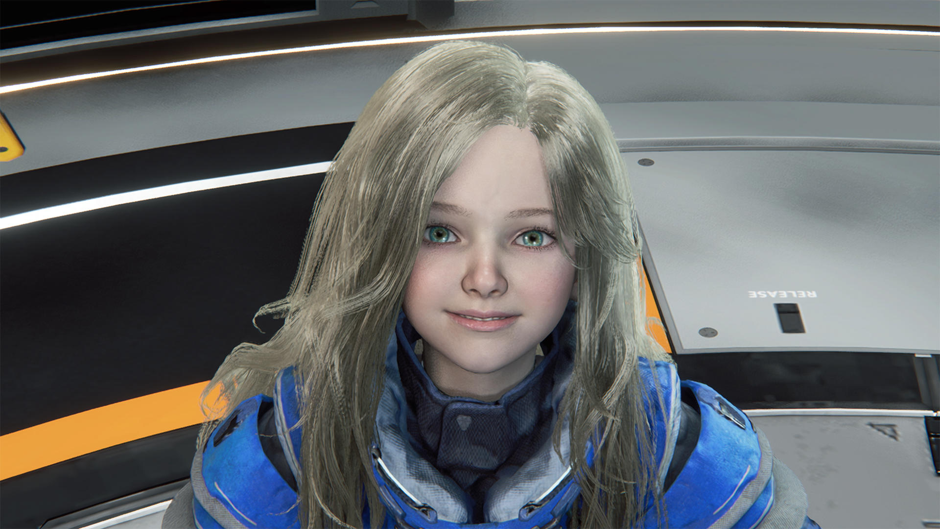 Ein junges Mädchen mit blonden Haaren und blauen Augen trägt eine blaue Jacke.